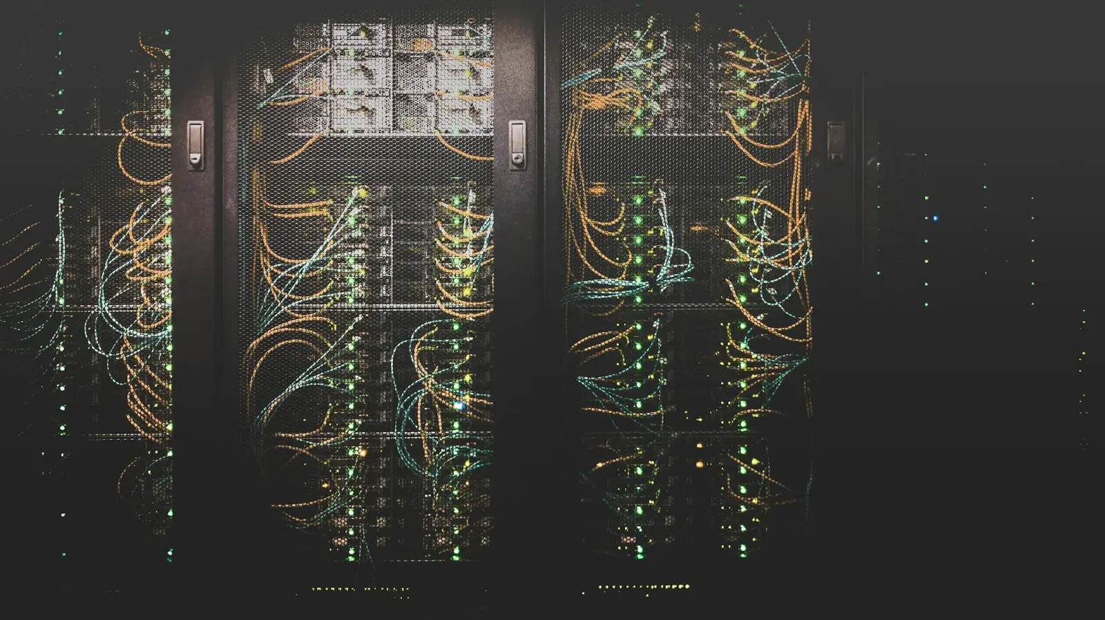 Network cables connected to server racks in a dark room